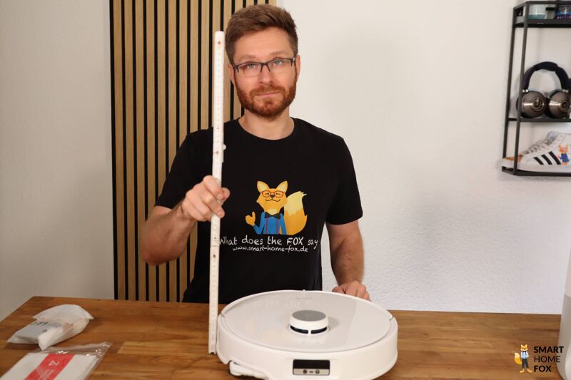 Der Saugroboter wird mit einem Lineal ausgemessen.